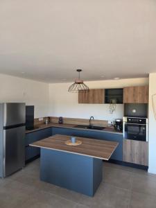 a kitchen with a blue island in the middle at Les embruns du retz in Chaumes en Retz