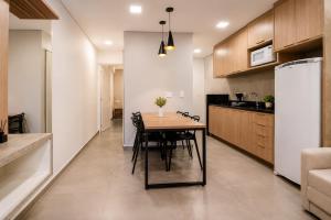 a kitchen and dining room with a table and a refrigerator at Yolanda Flats in Foz do Iguaçu +4 photos