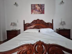 a bedroom with a large wooden bed with two night stands at Plomari Rum Evi in Plomari