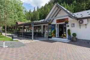 a store with a patio in front of a building at Хатинка у Румуна in Tatariv