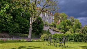a table and chairs in a park with a tree at Apartamenty Nad Rzeką in Polanica-Zdrój