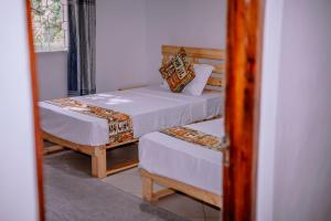a bedroom with two beds and a mirror at Avana Home in Arusha