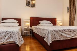 two beds in a small room with two lamps at Villa Žnjan in Split