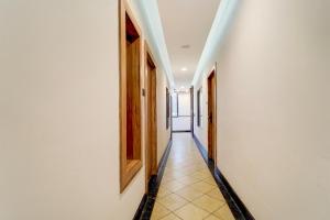 a hallway with white walls and a tile floor at Hotel O by OYO REFRESH INN & SUITES in Kozhikode