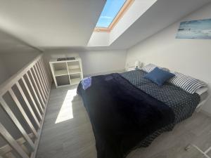 a bedroom with a bed with a blue blanket at Apartamenty Łuska Rowy in Rowy