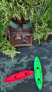 two surfboards and a man laying on a bed next to plants at Secret Spot Lagoon Dream in Moorea