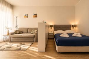 a bedroom with a bed and a couch at Apartament typu studio Doris 3 - 50m od plaży in Pobierowo