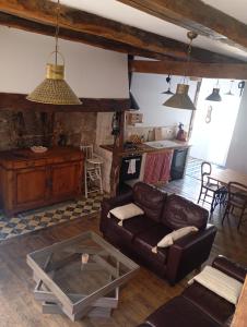 a living room with a couch and a table at Gîte Le Mansois in Marcillac-Vallon