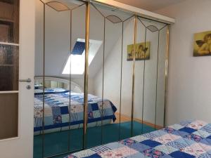 a bedroom with a mirrored closet with two beds at Schwarzwald Appartment in Freudenstadt