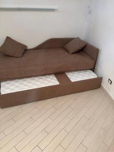 a brown couch in a room with a wooden floor at SnowWhite Home in Porto Ercole