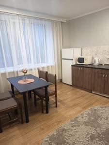 a kitchen with a table and chairs and a refrigerator at Comfort place in Ternopil
