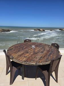 a wooden table with chairs on the beach at Riad d'exception vue mer au coeur de la médina Essaouira - Mandji Dream in Essaouira