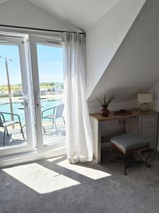a room with a desk and a window with a balcony at River Breeze BALCONY 2 in Littlehampton
