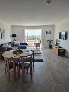 a living room with a table and a couch at River Breeze BALCONY 2 in Littlehampton