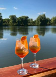two glasses with oranges in them sitting on a wooden table at Pensiunea Hubertus in Bistriţa