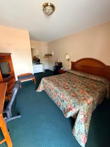 a hotel room with a bed and a television at Ranch House Motel in Marksville