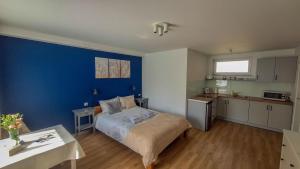 a bedroom with a bed and a blue wall at Apartamenty Nad Rzeką in Polanica-Zdrój