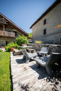 a group of picnic tables and chairs in a yard at Granuit Alpine Home in Sauze di Cesana
