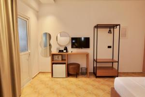 a room with a desk and a tv and a mirror at Abelia Hotel in Ksamil