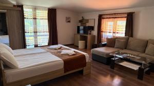 a hotel room with a bed and a couch at Къща за гости Гаджакови in Devin +42 photos