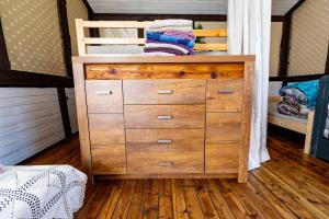 a wooden dresser in a bedroom with a bunk bed at Pie lacuksa in Tīnūži
