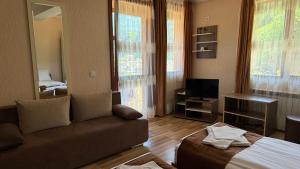 a living room with a couch and a television at Къща за гости Гаджакови in Devin