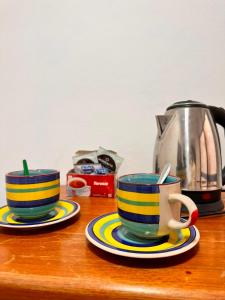 two cups on a wooden counter with a coffee pot at Habitación Privada in Libertador General San Martín +3 photos