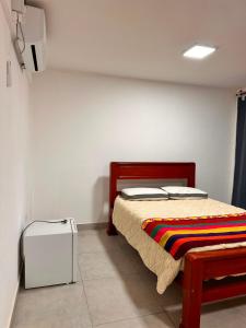 a bedroom with a bed and a suitcase at Habitación Privada in Libertador General San Martín