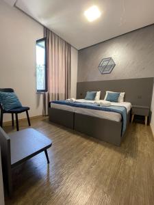 a bedroom with a large bed and a chair at Noragyugh Guest House in Yerevan