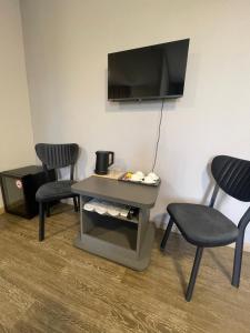 a room with two chairs and a table and a tv at Noragyugh Guest House in Yerevan