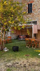 a yard with benches and a table and a tree at San Leo Albergo Diffuso in San Leo