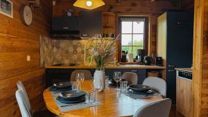 a dining room table with chairs and a vase of flowers at Chatka Wald in Kostrzyca