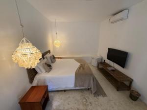 a bedroom with a bed and a flat screen tv at Beco do Mar Cumbuco in Cumbuco