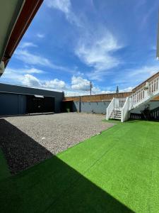 a yard with grass and a bridge in the background at MarDani Guesthouse & Car Rental - FREE SJO Airport Shuttle in Alajuela