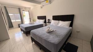 a bedroom with two beds with a stuffed duck on it at MarDani Guesthouse & Car Rental - FREE SJO Airport Shuttle in Alajuela