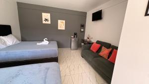 a living room with a bed and a couch at MarDani Guesthouse & Car Rental - FREE SJO Airport Shuttle in Alajuela