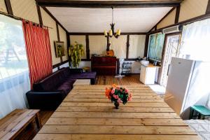 a living room with a wooden table with flowers on it at Pie lacuksa in Tīnūži