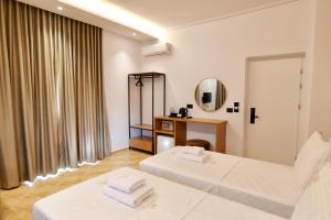 a hotel room with two beds and a mirror at Abelia Hotel in Ksamil +96 photos