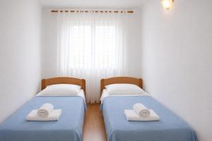 two beds in a bedroom with hats on them at Apartments Tonći and Iris in Primošten