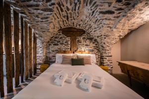 a bedroom with a bed with a stone wall at Granuit Alpine Home in Sauze di Cesana