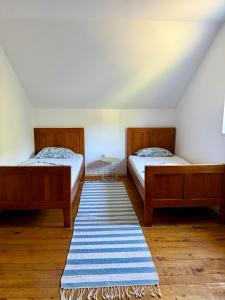 two beds in a room with a rug on the floor at Milovan in Cetinje
