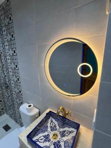 a bathroom with a blue and white sink and a mirror at Casa El Haouta in Chefchaouen +52 photos
