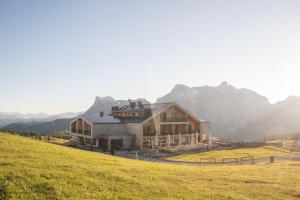 a large house on a hill in a field at Rifugio Alpino Pralongià in Corvara in Badia