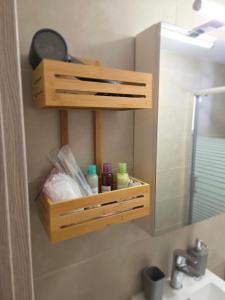 a bathroom with a wooden cabinet above a sink at Loutraki Cozy Loft in Loutraki +11 photos