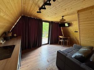 a living room with a couch and a large window at Chachkari Cottage in Gogasheni