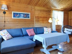 a living room with a blue couch and a table at 4 person holiday home in Strömstad in Strömstad