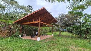 a pavilion with tables and chairs in a field at Cabaña Vista de Oro 2 in Paraíso