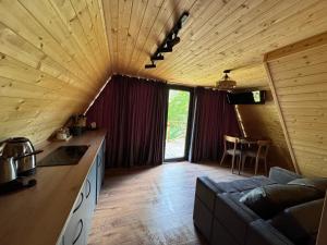 a kitchen and living room in a log cabin at Chachkari Cottage in Gogasheni