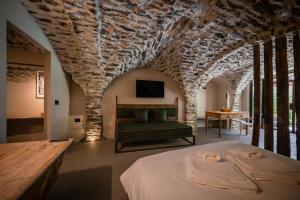 a bedroom with a bed and a stone wall at Granuit Alpine Home in Sauze di Cesana