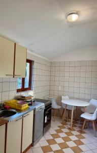 a kitchen with a sink and a table and chairs at Milovan in Cetinje